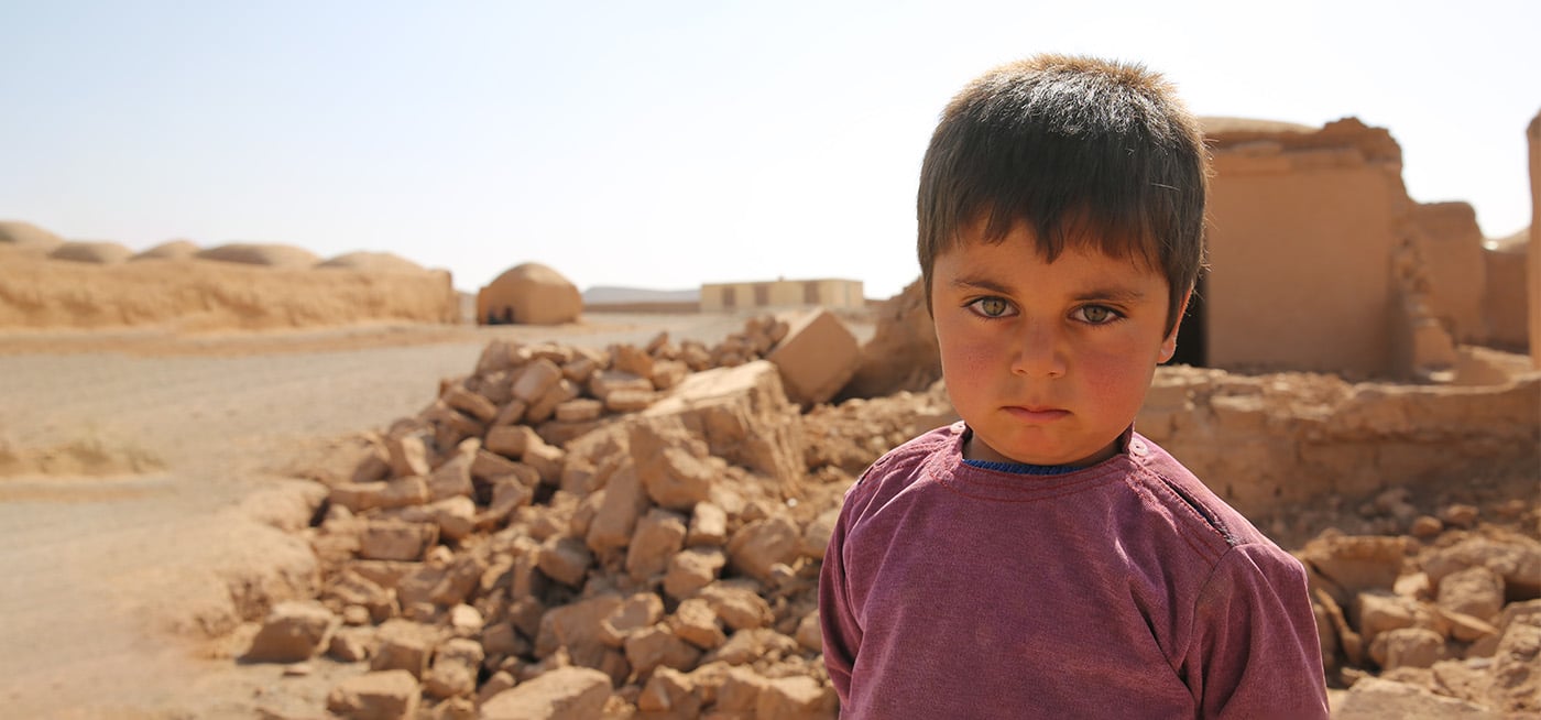 Jawid (4) foran ruiner i Afghanistan