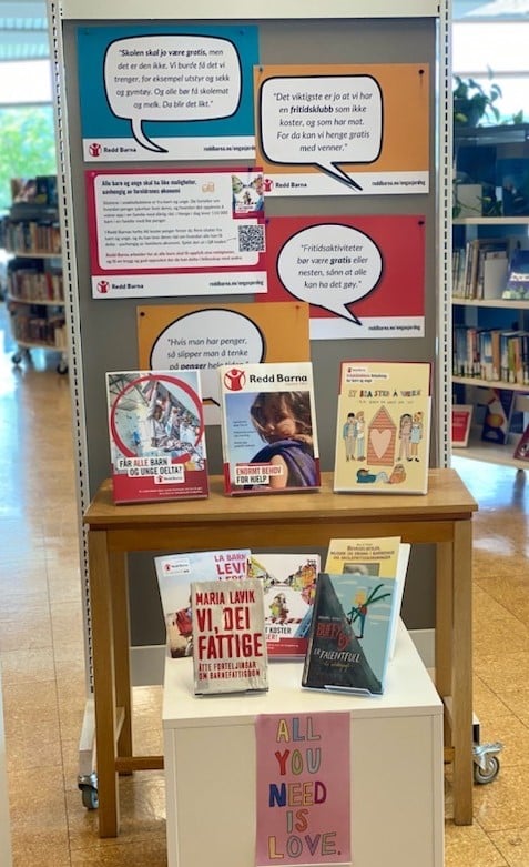 Foto av en utstilling på Tynset bibliotek med plakater om familiefattigdom og relevante bøker om temaet. 